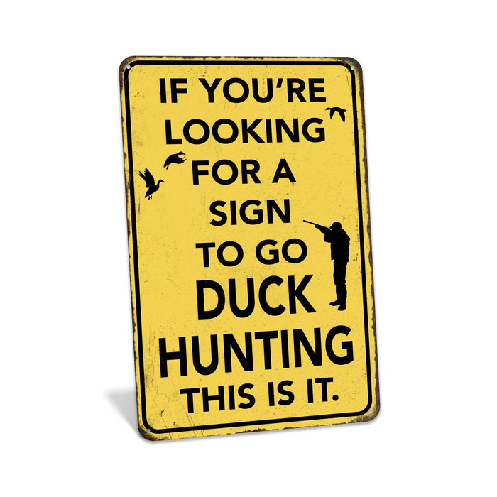 Rustic yellow metal duck hunting sign reading If You're Looking for a Sign to Go Duck Hunting This Is It with hunter and flying ducks silhouette