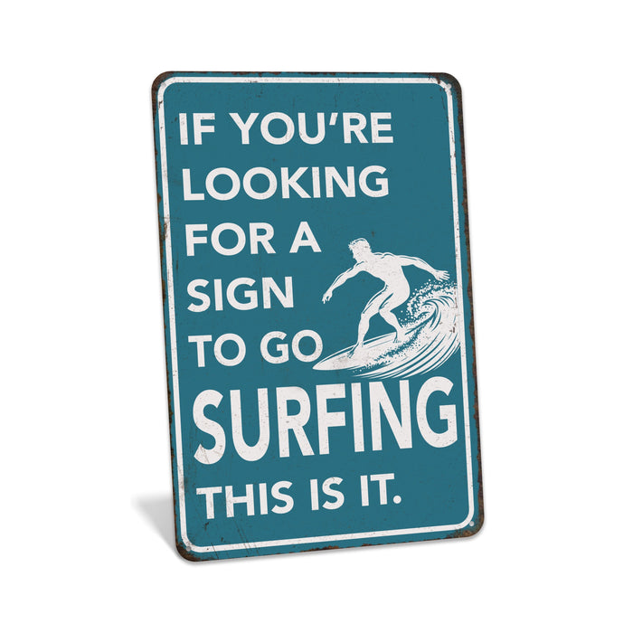 Rustic teal metal surfing sign reading If You're Looking for a Sign to Go Surfing This Is It with surfer on wave silhouette