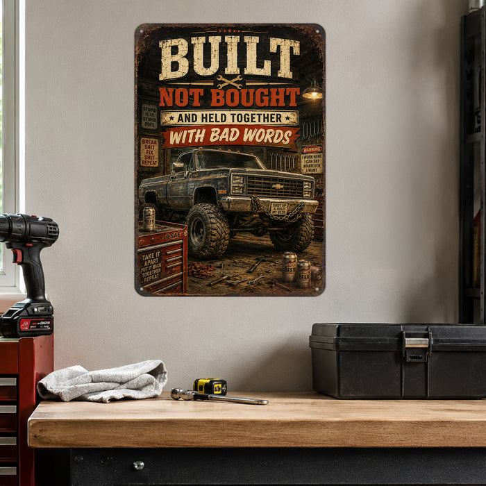 Built Not Bought Truck Garage metal sign with vintage layout with lifted square-body Chevy K10 on mud tires, tool chest