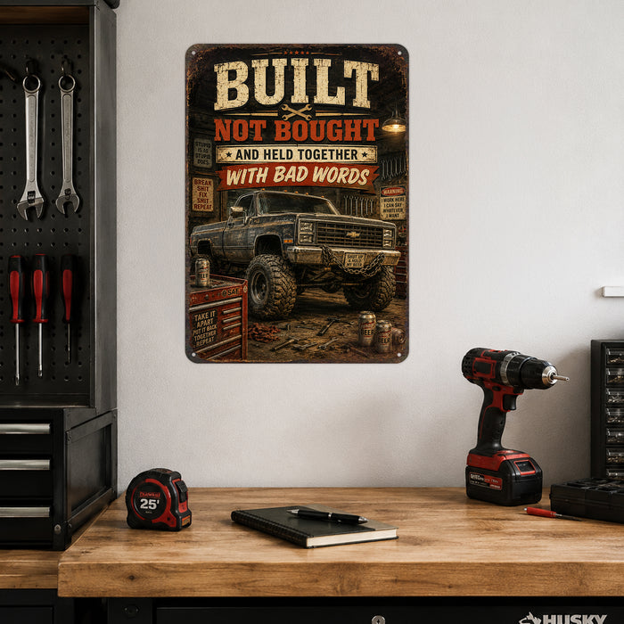 Built Not Bought Truck Garage metal sign with vintage layout with lifted square-body Chevy K10 on mud tires, tool chest