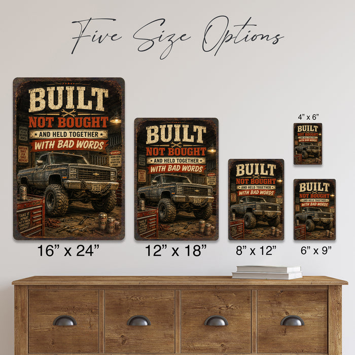Built Not Bought Truck Garage metal sign with vintage layout with lifted square-body Chevy K10 on mud tires, tool chest